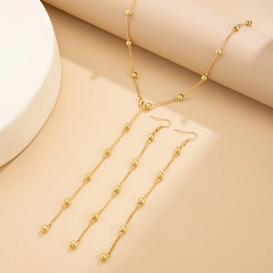 Detail of gold jewelry set showing CCB beaded chain necklace and long tassel earrings