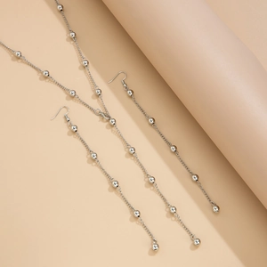 Close-up of minimalist silver beaded Y-necklace and matching hook earrings set