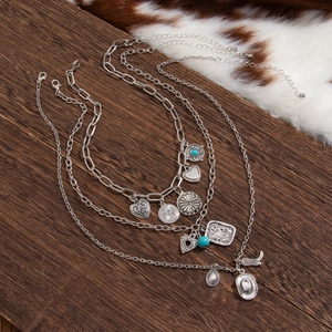 Detail of bohemian layered necklace set featuring turquoise beads and western charms