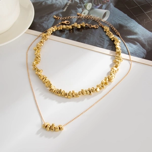 Vue à plat d'un ensemble de colliers dorés à deux rangs avec perles irrégulières