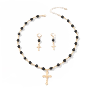 Ensemble bijoux collier pendentif croix dorée et boucles d'oreilles sur fond blanc
