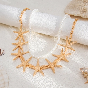 Detail of double-layered starfish pendants and pearl beads on beach themed necklace