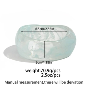 Détails d'un large bracelet en résine marbrée montrant les dimensions et la texture fumée