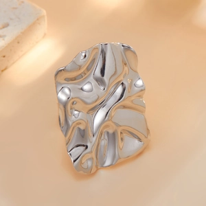 Detailed view of silver irregular wrinkled ring featuring fluid metal texture finish