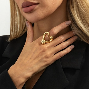 Detailed close-up of a gold sculptural heart ring featuring irregular textured pleats