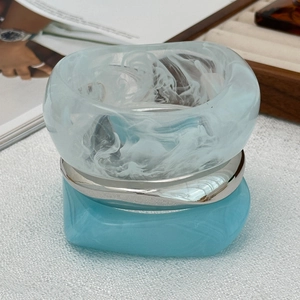 Détail de bagues en résine épaisse avec texture bleue tourbillonnante et métal argenté