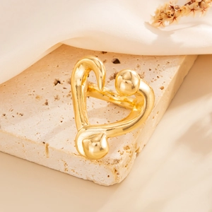 Minimalist gold nail heart ring featuring creative abstract design on a textured stone base