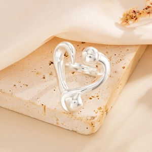 Detail of silver irregular ring with spherical elements on beige travertine stone