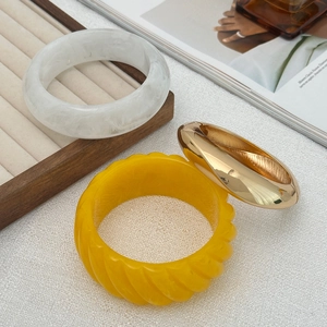 Three-piece set featuring marble resin, yellow twisted resin, and gold metal bangles