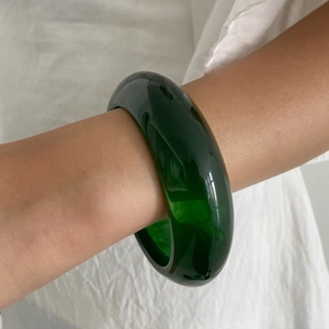 Retro minimalist wide resin bangle in dark green with a translucent emerald finish