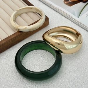 Three-piece stackable bracelet set with ivory resin, gold metal and dark green bangle
