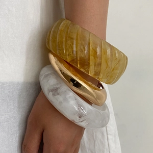 Three-piece stackable bracelet set with amber resin, gold metal and marble texture
