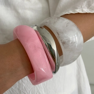 Close-up of thick resin bangle set in bright pink, silver, and marbled white