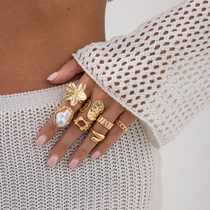 Goldenes Ring-Set mit Barockperlen und Blumenakzenten an der Hand des Models
