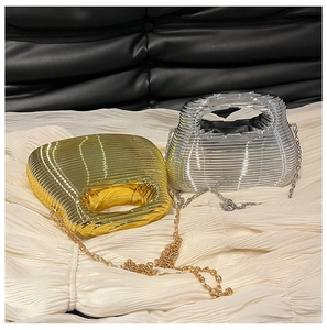 Close-up of gold and silver ripple texture evening bags with metal chain straps
