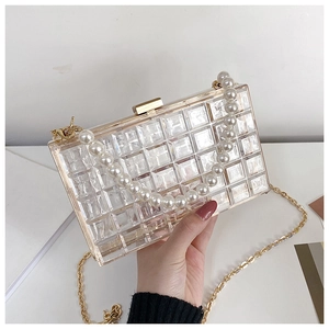 Détail de la pochette en acrylique transparent avec anse en perles et fermoir doré