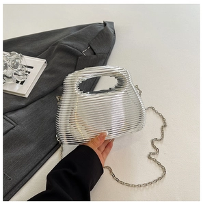 Detailed view of silver evening bag with horizontal ripples and metal chain strap