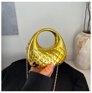 Detail einer glänzenden goldenen Halmondtasche mit Steppmuster und rundem Griff