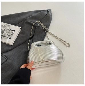 Close-up of silver wavy evening bag with metallic finish and delicate chain strap detail