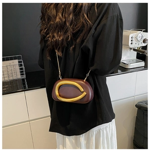 Dunkelrote Abendtasche mit markantem goldenem Metallringgriff und eleganter Kette