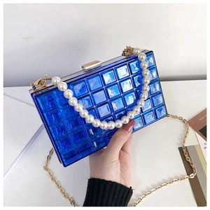 Gros plan sur l'embrayage en acrylique bleu royal avec poignée en perles et chaîne