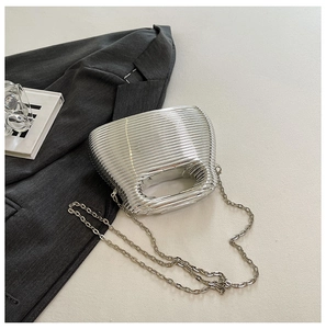 Detail of silver wavy evening bag with metallic texture and sleek chain strap