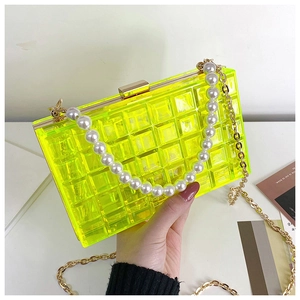 Détail d'une pochette boîte en acrylique jaune fluo avec poignée en perles