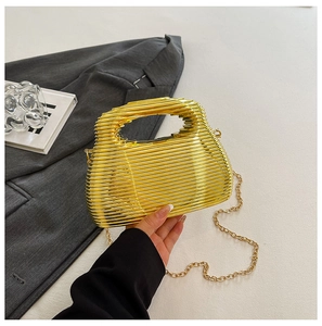 Detailed view of luxury gold evening clutch with ribbed metal design and chain strap