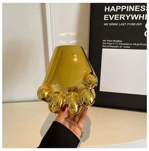 Détail du sac de soirée patte d'ours dorée avec finition miroir brillante et chaîne