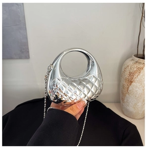 Detail der silbernen Metallic-Halbmondtasche mit Steppmuster und Perlenkettenriemen