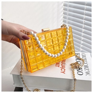 Détail du sac à bandoulière en acrylique orange avec motif matelassé et perles