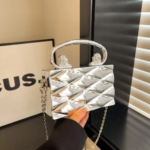 Silver geometric box clutch featuring ornate lion head ring handles and a sleek chain strap