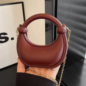 Chic burgundy half-moon handbag with gold chain strap and elegant top handle detail