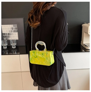 Détail de la pochette en acrylique marbré vert avec poignée argentée et chaîne