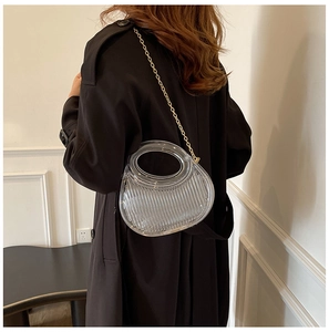 Detailed view of a semi-circular transparent pleated crossbody bag with gold chain strap