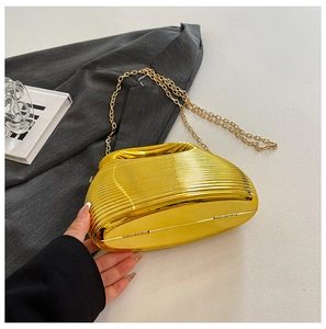 Detailed view of luxury gold ripple clutch bag with elegant metal chain strap and texture