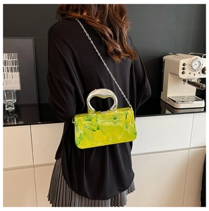 Sac de soirée en acrylique marbré vert et jaune avec poignée argentée sur modèle