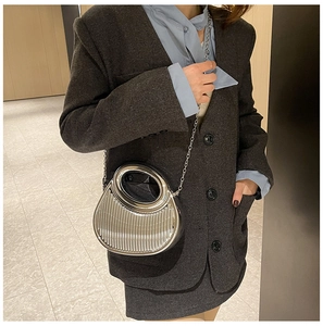 Detail of silver metallic pleated crossbody bag with circular handle and chain strap