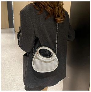Detail of silver metallic textured crossbody bag with ripple design and chain strap