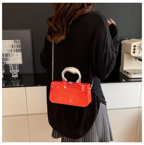 Détail du sac à main rouge effet marbre avec poignée anneau argentée et bandoulière chaîne