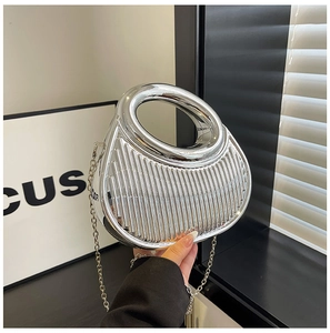 Macro view of metallic silver pleated handbag featuring round handle and chain strap