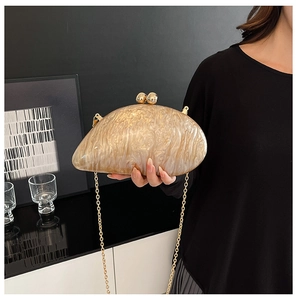 Detail of champagne marble acrylic evening bag with gold sphere clasps and chain strap