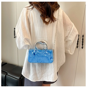 Détail du sac boîte en acrylique marbré bleu avec poignée argentée et chaîne