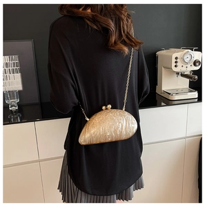 Champagne marble texture evening clutch bag shown as a crossbody on model