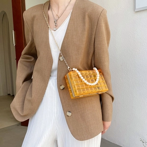 Sac bandoulière orange en acrylique matelassé avec chaîne dorée et poignée en perles