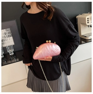 Pink marble texture acrylic evening bag with gold chain worn by a model in a stylish interior