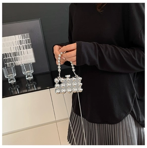 Detail van zilveren acryl box-tas met metalen bollen en kralen handvat voor dames