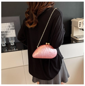 Detail of pink marble acrylic evening bag with gold sphere clasp and chain on model