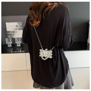 Detail van luxe met parels bezette mini-tas in de vorm van een parfumflesje