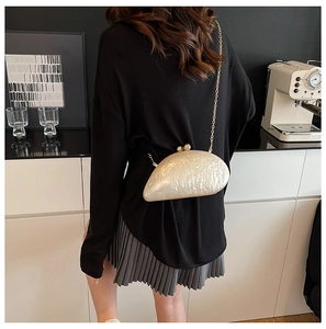Chic off-white pearl acrylic clutch with gold chain strap shown on a model
